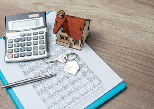 Photo of a calculator, expenses and a house