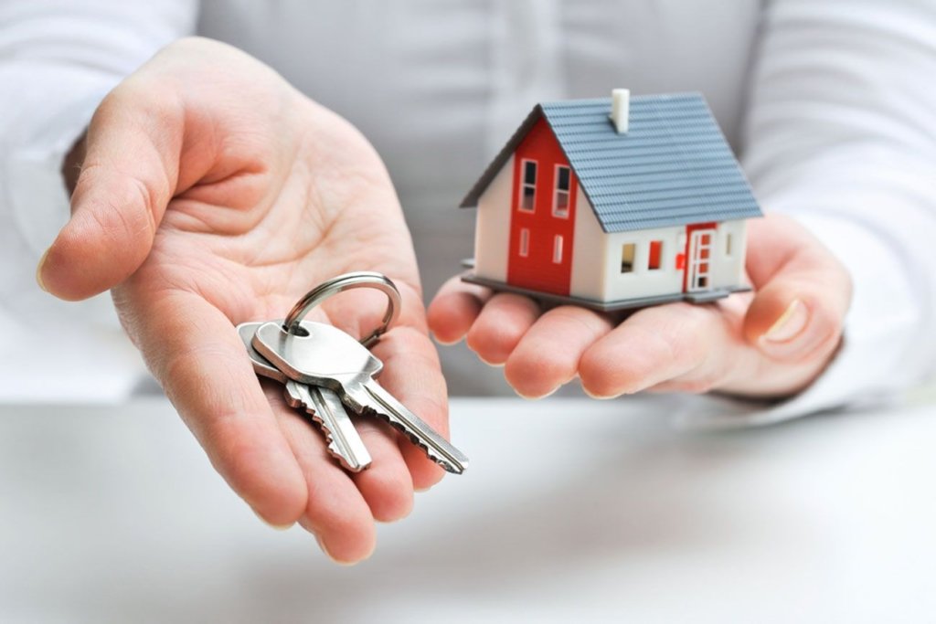 Photo of someone holding a house and keys