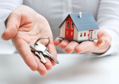 Photo of someone holding a house and keys