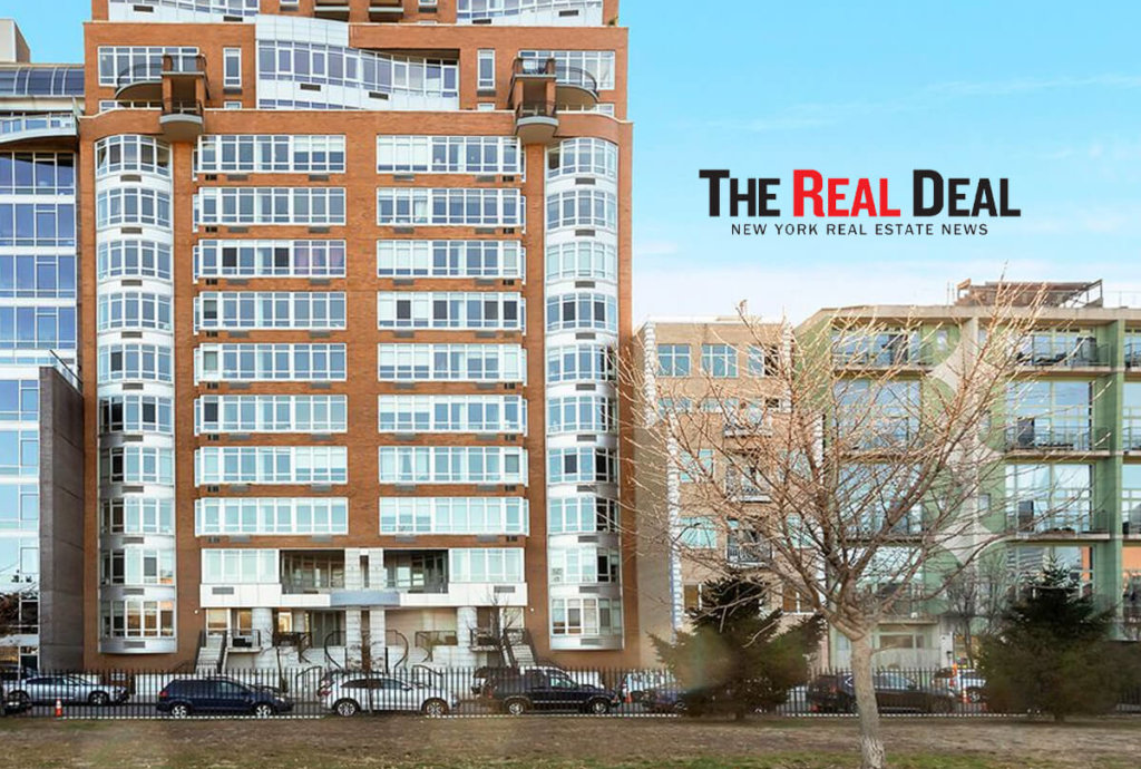 Photo of The Real Deal logo next to buildings