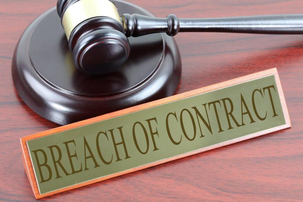 Breach of contract sign next to gavel